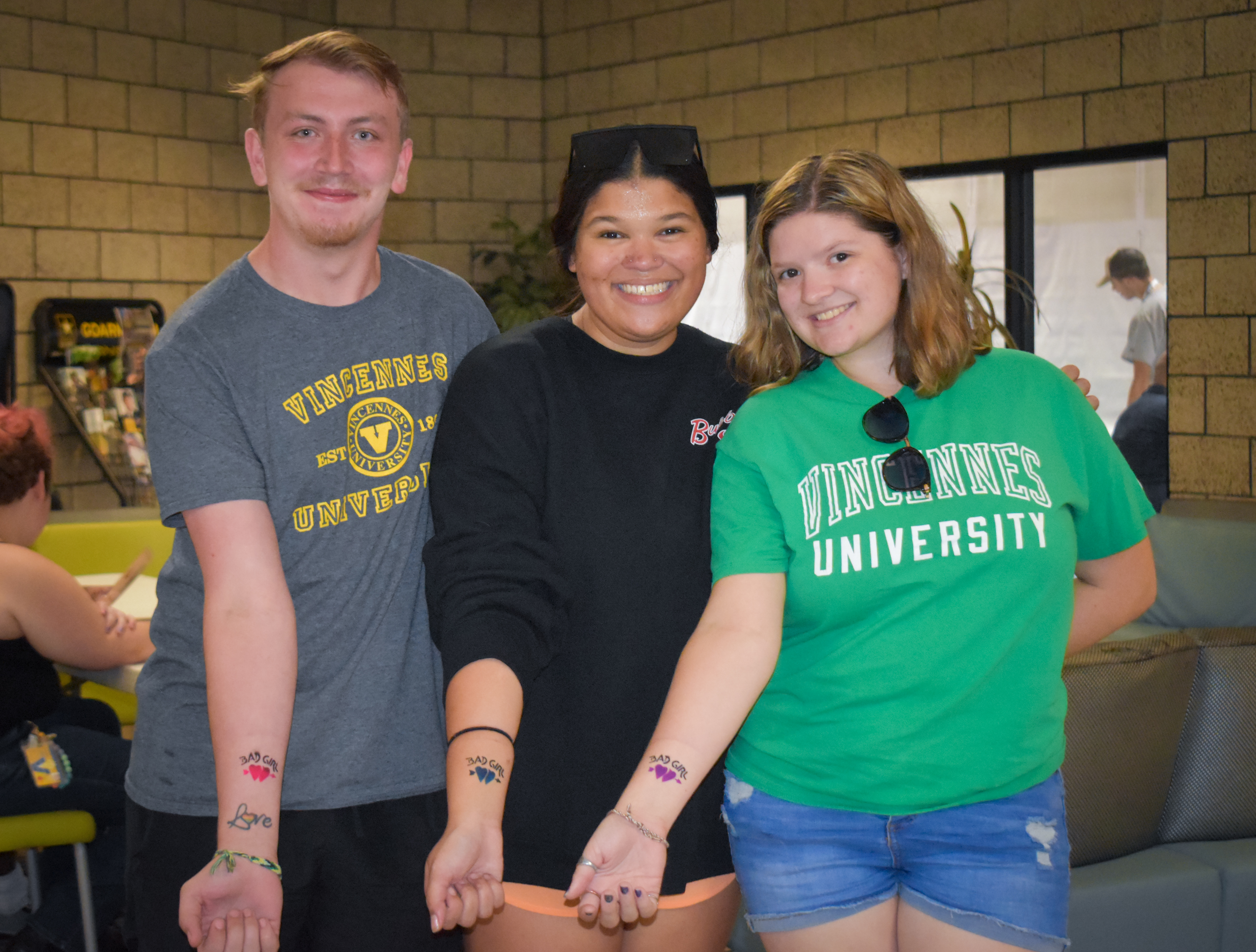 1 male and 2 female VU students show off the temporary tattoos at Roc the Rec.